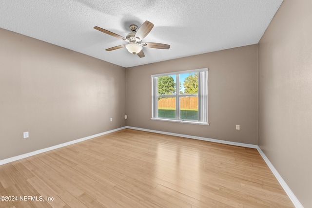 unfurnished room featuring light hardwood / wood-style flooring, ceiling fan, and a textured ceiling