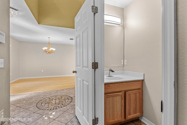 bathroom with a textured ceiling, wood-type flooring, and vanity