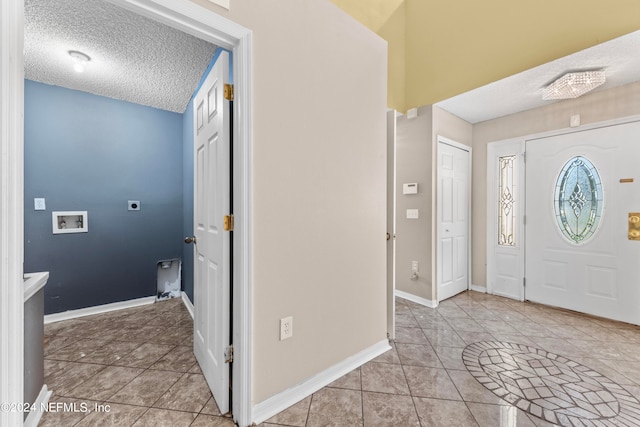 entrance foyer featuring a textured ceiling and light tile patterned floors