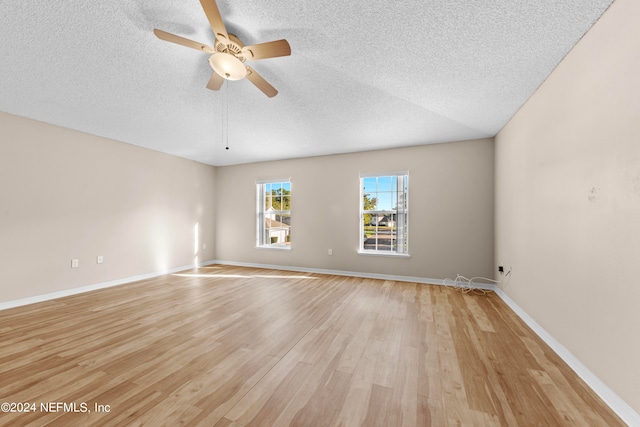 empty room with a textured ceiling, ceiling fan, and light hardwood / wood-style flooring