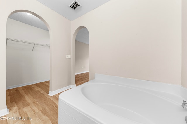 bathroom featuring a bath and hardwood / wood-style flooring