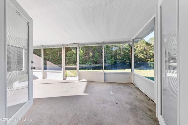 unfurnished sunroom featuring a water view