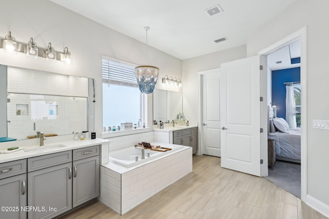 ensuite bathroom with a wealth of natural light, a sink, visible vents, and a shower stall