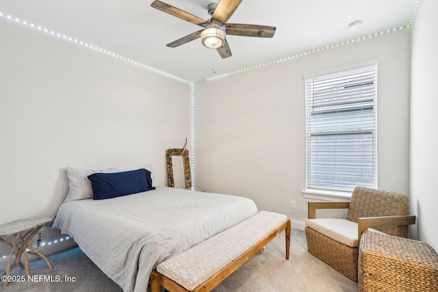 bedroom featuring baseboards, a ceiling fan, and light colored carpet