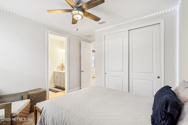 bedroom featuring a closet, visible vents, ceiling fan, ensuite bath, and baseboards