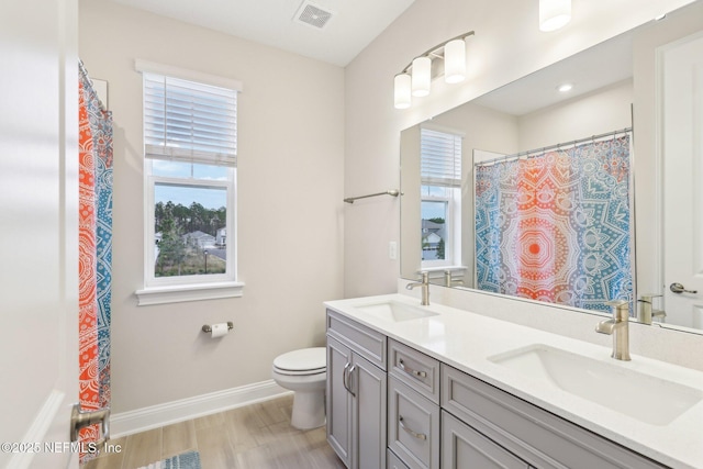 full bathroom featuring a healthy amount of sunlight, visible vents, and a sink