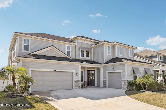 view of front of house with an attached garage, stone siding, and driveway