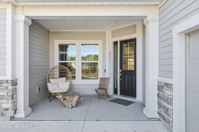 entrance to property with stone siding and a porch