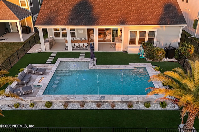 back of property featuring a fenced backyard, a fenced in pool, a patio, and roof with shingles