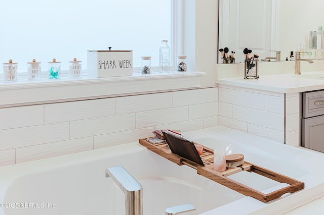 full bath featuring a garden tub and vanity