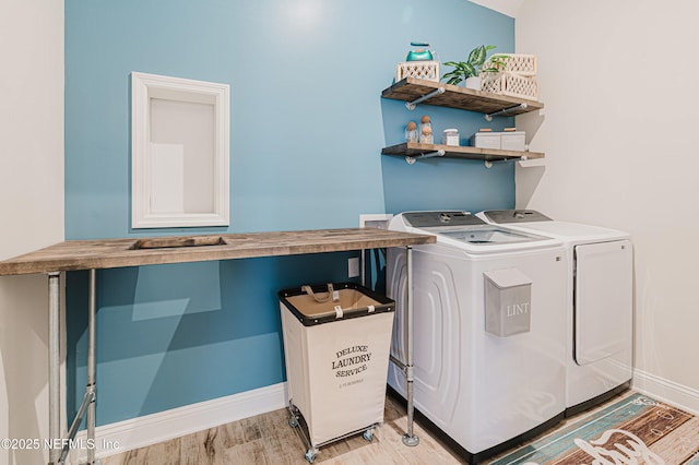 washroom with light wood-style floors, washer and dryer, laundry area, and baseboards