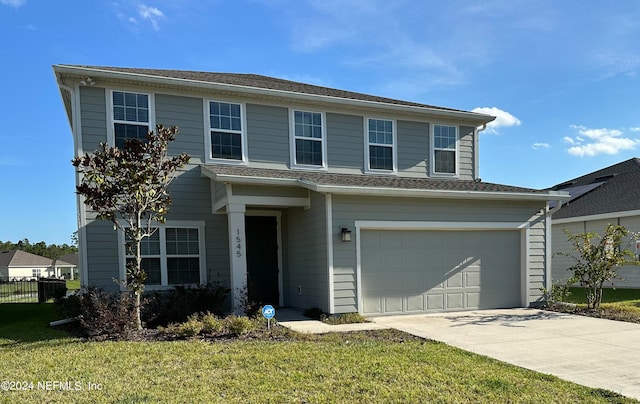 front of property featuring a front lawn and a garage