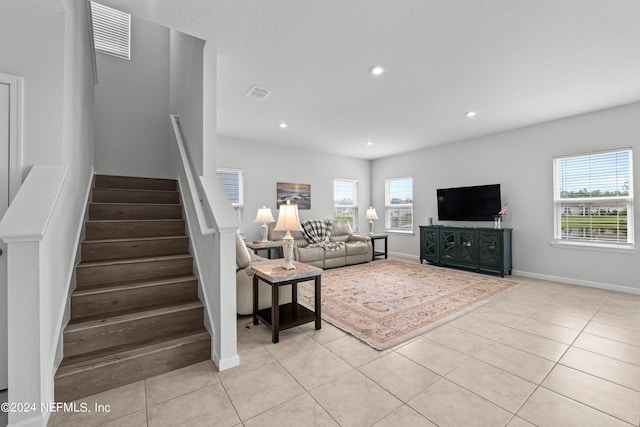 unfurnished living room featuring light tile patterned floors and a healthy amount of sunlight