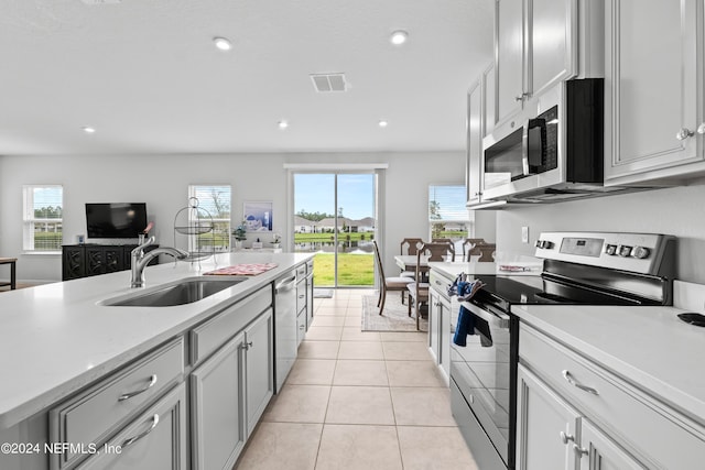 kitchen with light tile patterned floors, appliances with stainless steel finishes, and sink