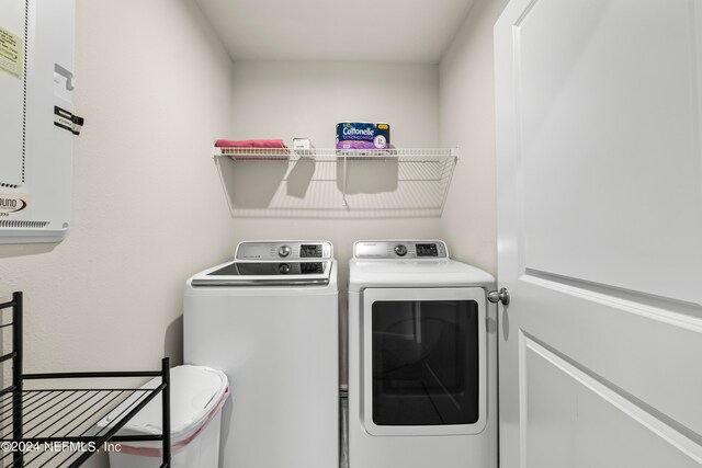 clothes washing area with washer and clothes dryer