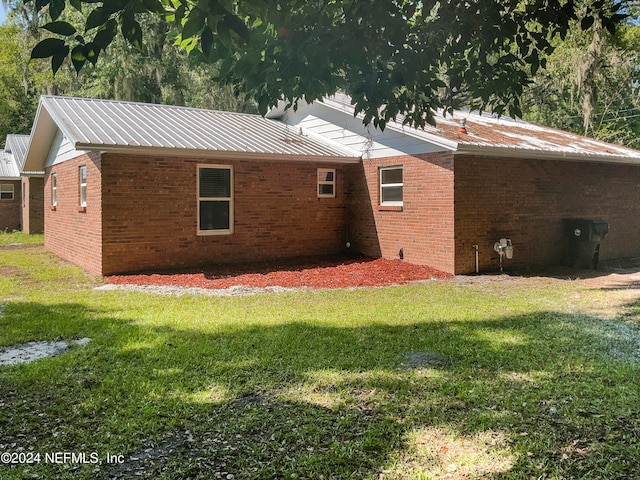 rear view of house featuring a lawn