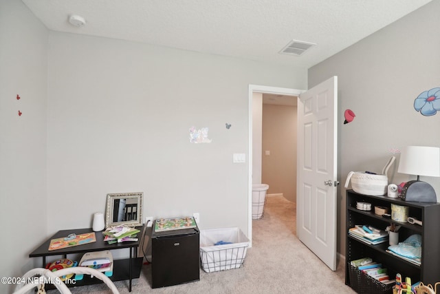 carpeted home office featuring a textured ceiling