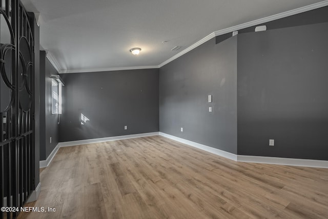 unfurnished room with light wood-type flooring and ornamental molding