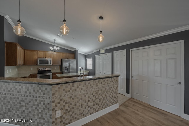 kitchen with kitchen peninsula, appliances with stainless steel finishes, vaulted ceiling, decorative light fixtures, and light hardwood / wood-style flooring