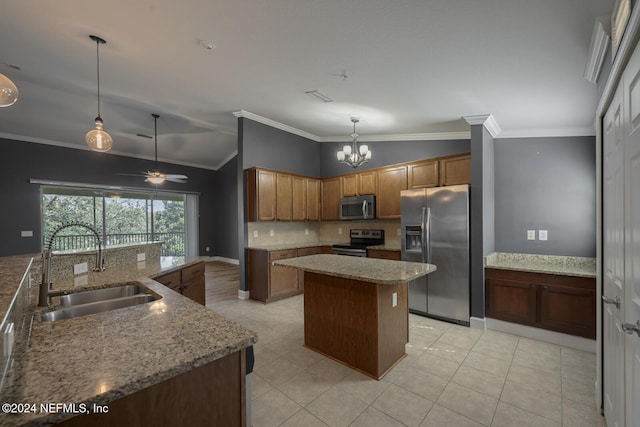 kitchen featuring lofted ceiling, sink, decorative light fixtures, a kitchen island, and stainless steel appliances