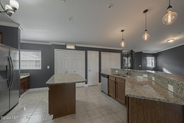 kitchen featuring sink, an island with sink, stainless steel appliances, and decorative light fixtures