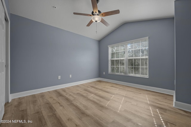 spare room with ceiling fan, light hardwood / wood-style flooring, and vaulted ceiling