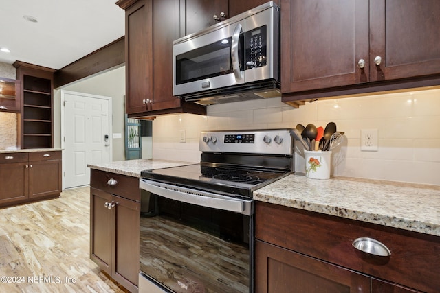 kitchen featuring stainless steel appliances, light hardwood / wood-style floors, light stone counters, and dark brown cabinets