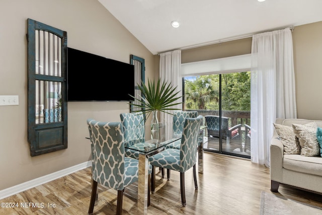 dining space with hardwood / wood-style floors and vaulted ceiling