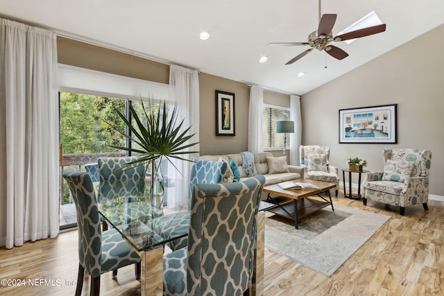 living room with light wood-type flooring, plenty of natural light, and vaulted ceiling