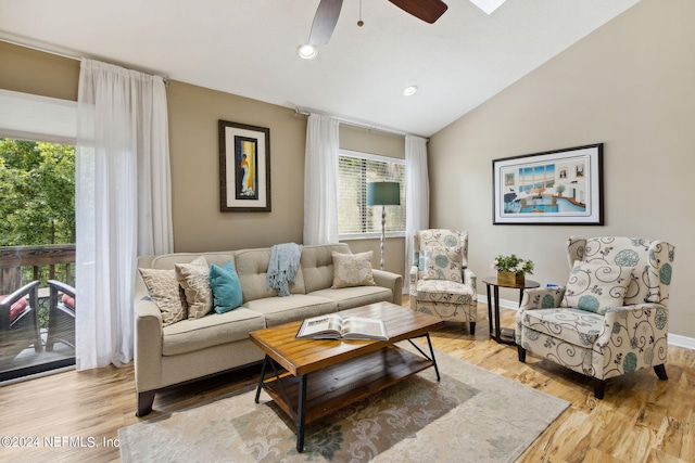 living room featuring lofted ceiling, ceiling fan, and light hardwood / wood-style flooring