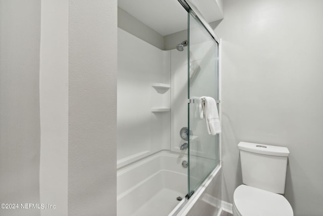 bathroom featuring shower / bath combination with glass door and toilet