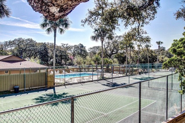 view of tennis court with a community pool