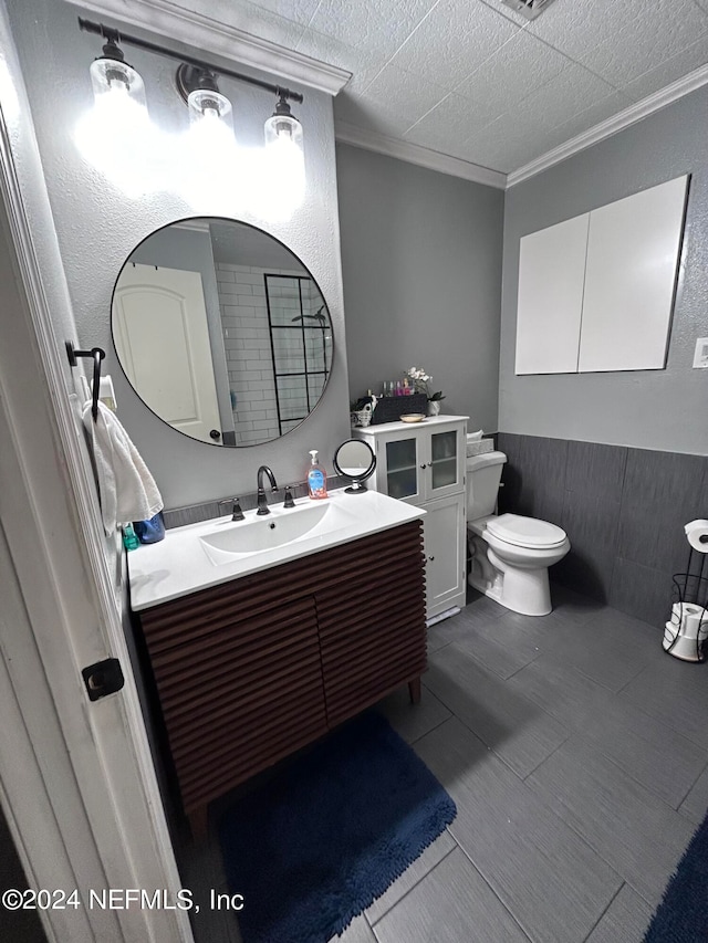 bathroom with a textured ceiling, crown molding, vanity, and toilet