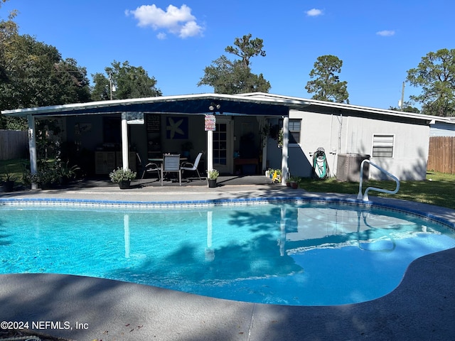 view of swimming pool with central AC unit and a patio area