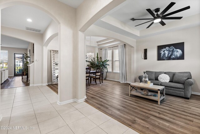 living room with a healthy amount of sunlight, ceiling fan, and light hardwood / wood-style flooring