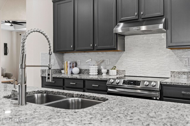 kitchen with light stone countertops, ceiling fan, stainless steel range with electric cooktop, and tasteful backsplash