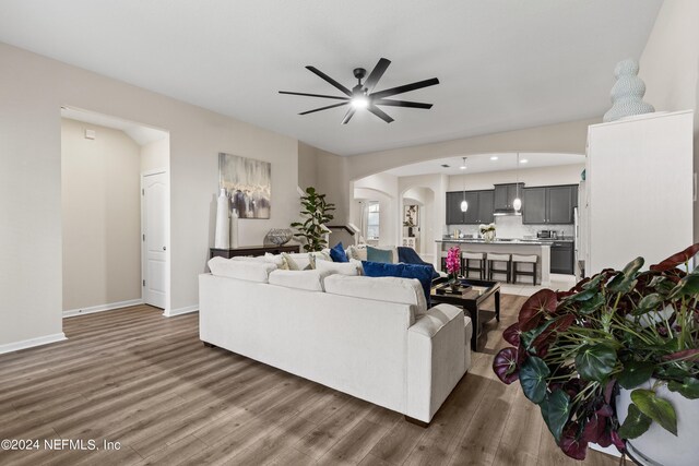 living room with ceiling fan and dark hardwood / wood-style flooring