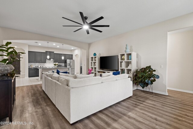 living room with ceiling fan and dark wood-type flooring