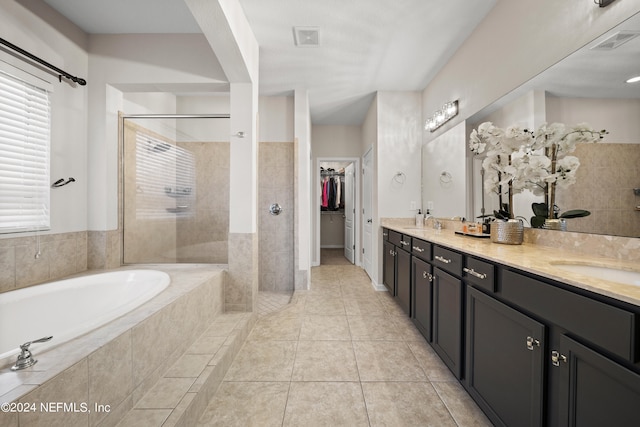 bathroom featuring plus walk in shower, tile patterned flooring, and vanity