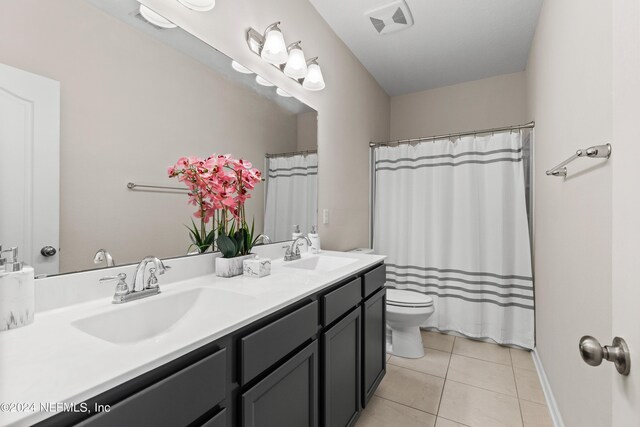 bathroom with curtained shower, vanity, toilet, and tile patterned floors