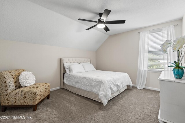 carpeted bedroom with vaulted ceiling, ceiling fan, and a textured ceiling