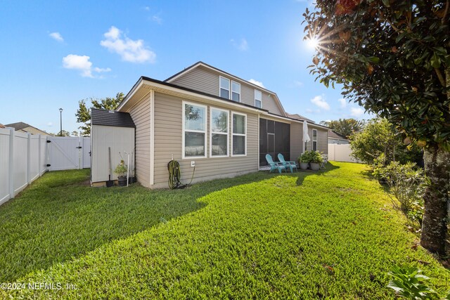 rear view of property featuring a lawn and a patio