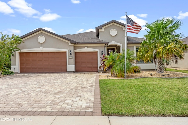 view of front of property with a front yard and a garage