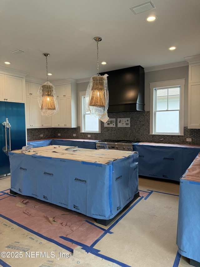 kitchen with decorative light fixtures, wooden counters, white cabinets, custom exhaust hood, and built in refrigerator