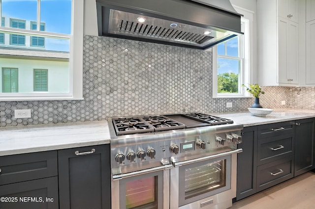 354 River Breeze Dr Lot 3, Ponte Vedra, FL 32081 - kitchen with double oven range, wall chimney exhaust hood, backsplash, and light stone counters