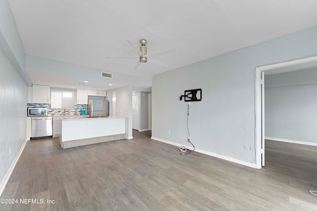 unfurnished living room with ceiling fan and hardwood / wood-style floors