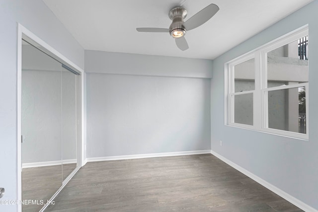 unfurnished bedroom with ceiling fan, a closet, and dark hardwood / wood-style floors