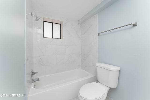 bathroom featuring tiled shower / bath combo and toilet