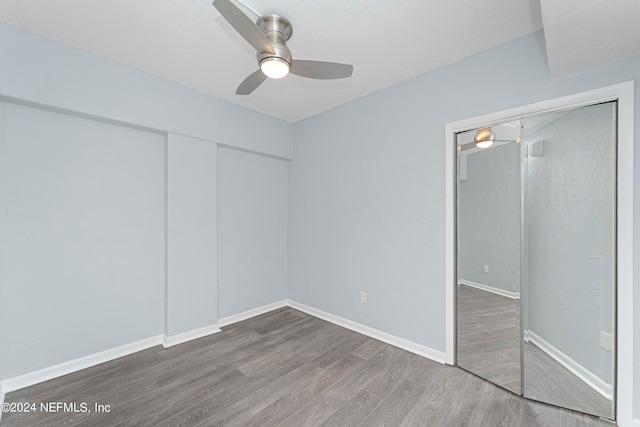 unfurnished bedroom featuring ceiling fan, a closet, and hardwood / wood-style flooring