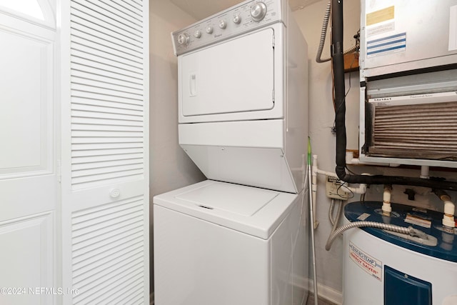 laundry room with water heater and stacked washing maching and dryer